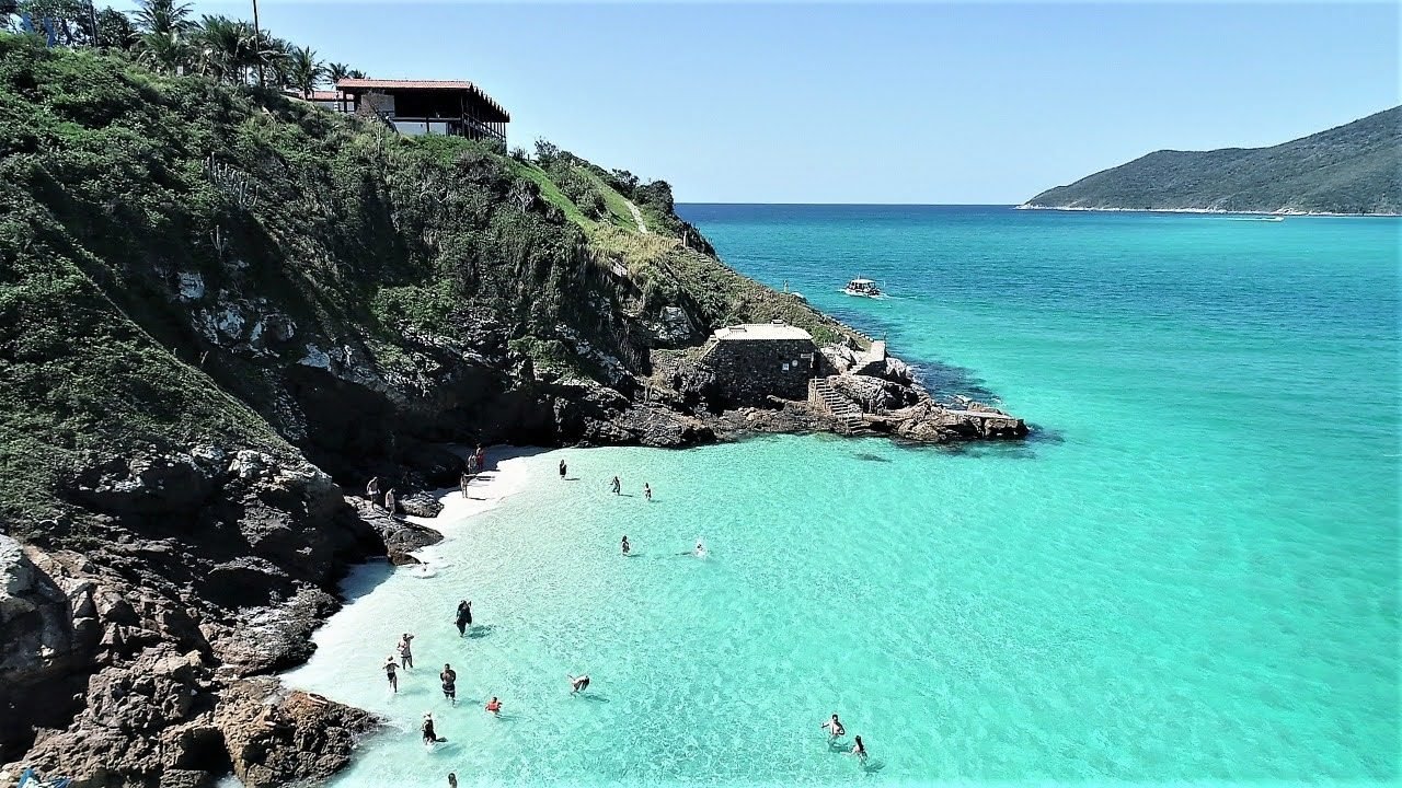Vista aérea das Prainhas do Pontal do Atalaia, em Arraial do Cabo, com água clara e areia branca